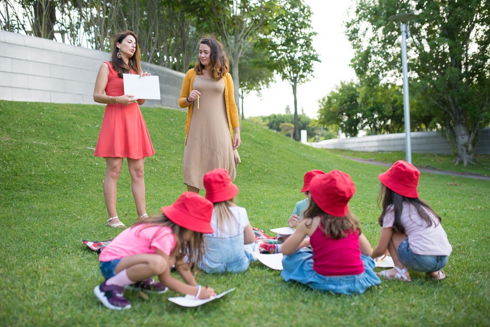 Educadoras a orientar uma atividade com um grupo de crianças ao ar livre